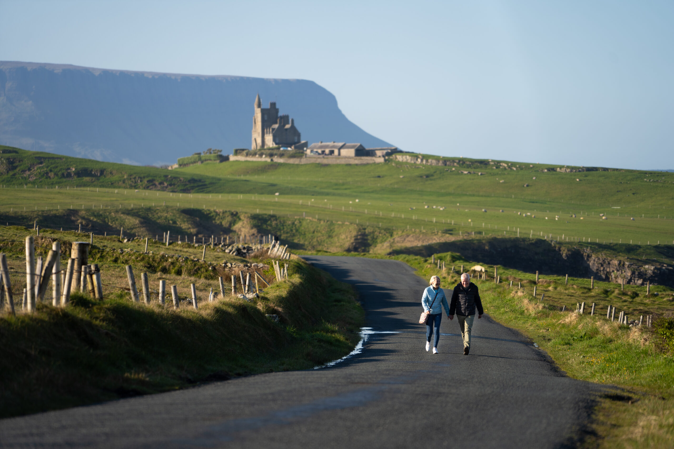 Couple walking along scenic road near Benbulben mountain in County Sligo